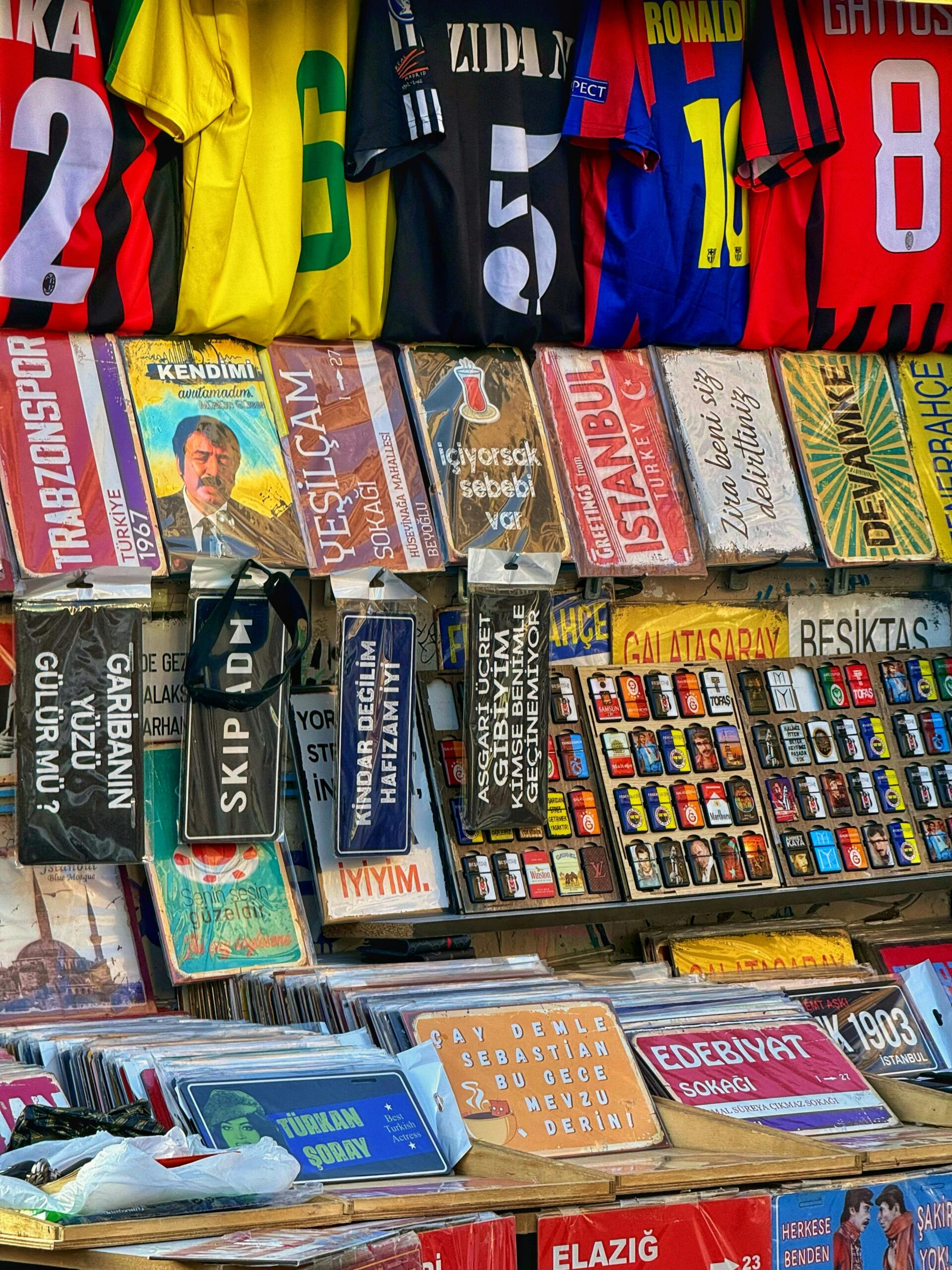 Vibrant display of jerseys, signs, and souvenirs at a street market stall in Istanbul.